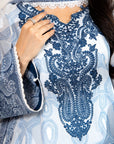 Close-up of a blue and white embroidered garment with intricate patterns.