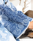 Blue and white patterned fabric with lace trim on a wooden surface