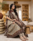 Woman in a patterned dress sitting in a cozy room with wooden shelves and decor.