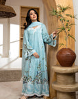 Woman in a light blue floral dress standing in a room with wooden arch and vase.