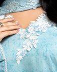 Close-up of a light blue garment with white lace details