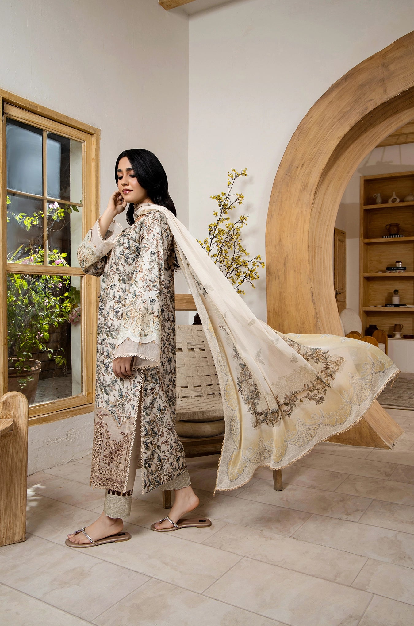 Woman in traditional outfit with a long scarf in a room with wooden decor