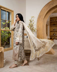 Woman in traditional outfit with a long scarf in a room with wooden decor