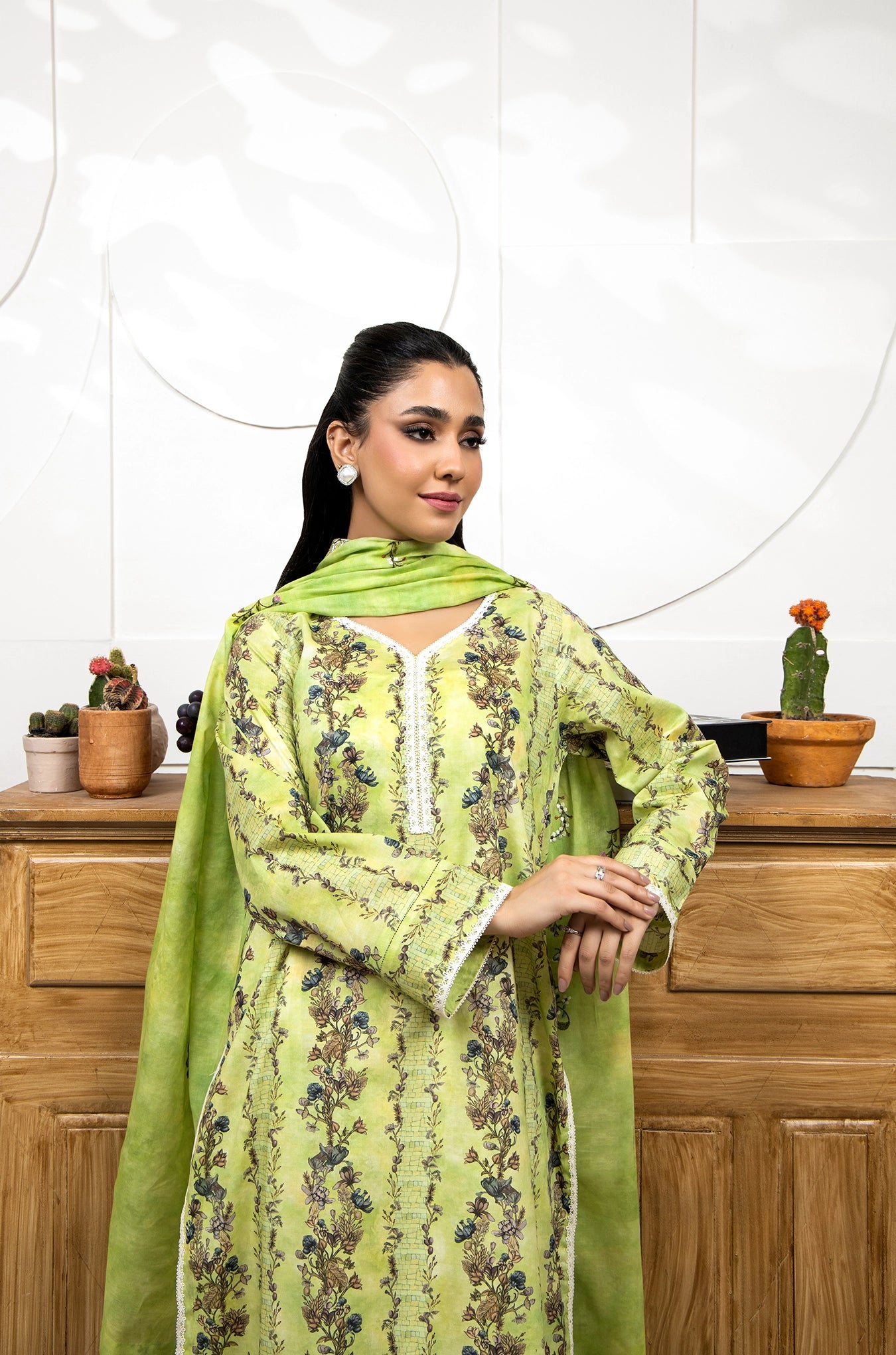 Woman wearing a green floral dress with a white background