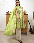 Woman wearing a green floral dress with a matching dupatta in a room setting.
