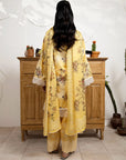 Person wearing a yellow floral outfit standing in front of a wooden cabinet.