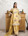 Woman in a yellow floral dress standing in front of a wooden cabinet.